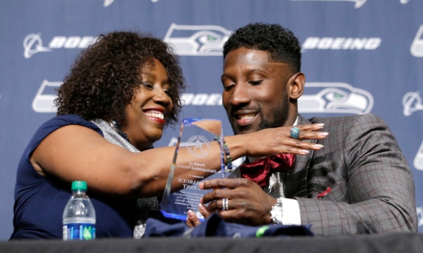 Seattle Seahawks' Marcus Trufant, left, is embraced by his mother, Constance Trufant, as she presented him with an award from the Trufant Family Foundation at a news conference announcing his retirement from football after signing with the team a day earlier, Thursday, April 24, 2014, in Renton, Wash. Trufant started 125 games in a Seattle career that lasted from 2003 to 2012. The cornerback was a first-round pick in 2003 out of Washington State and immediately moved into the starting lineup, playing a key role on the 2005 team that advanced to the franchises first Super Bowl. (AP Photo/Elaine Thompson)